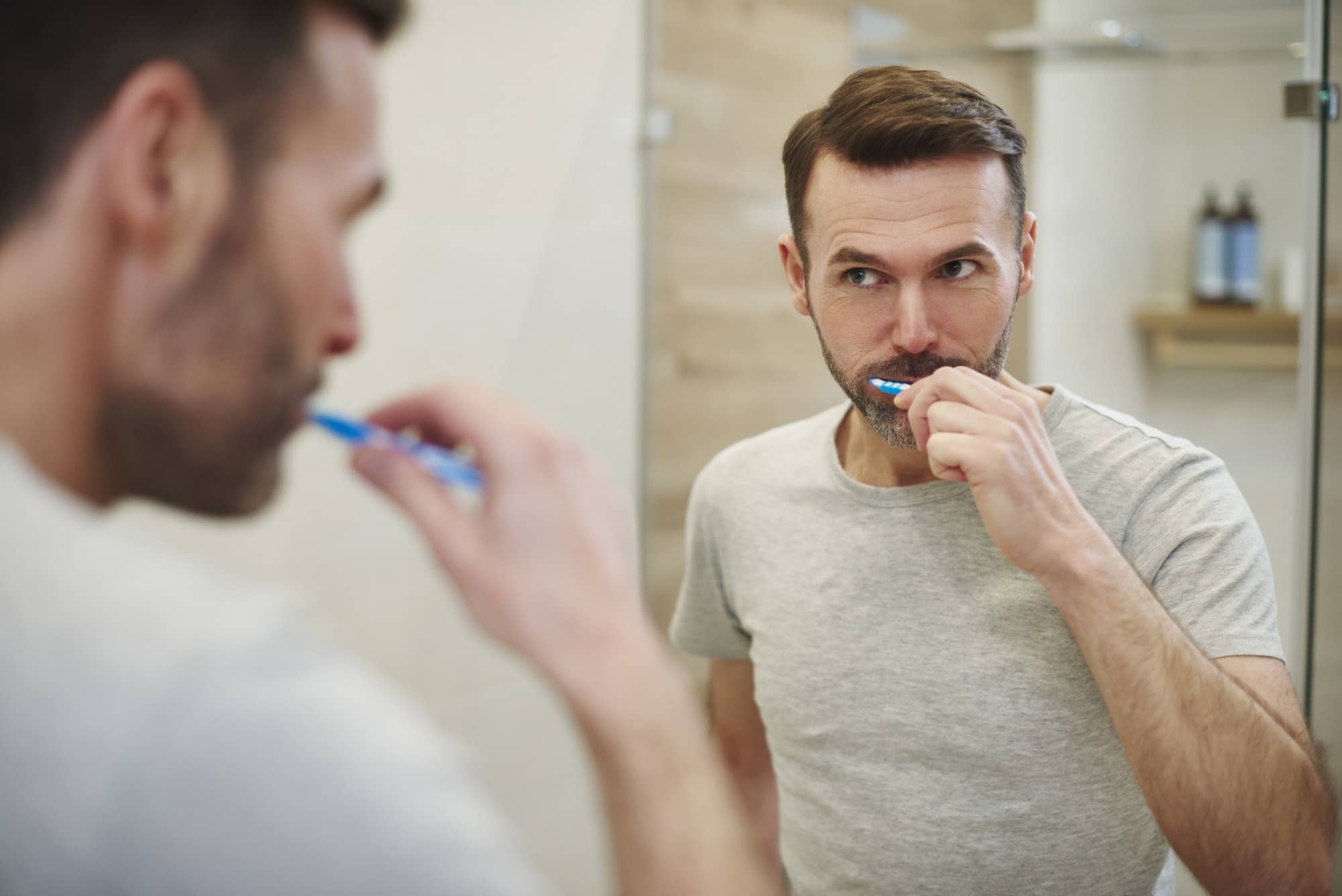 Man cleaning teeth in bathroom